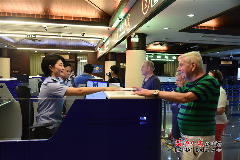 三亚边检站民警在凤凰岛国际邮轮港联检大厅为世鹏旅居号邮轮旅客办理快速通关手续。王雅琳 摄.jpg