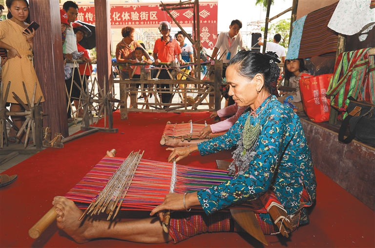 在2019海南（陵水）“三月三”民族风情街系列活动现场，群众在观看黎锦编织技艺展示。武昊 摄.jpg
