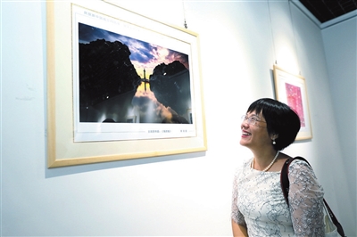 摄影爱好者在摄影展现场观展。 记者 袁永东 摄.jpg