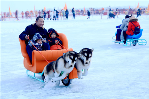 图为2020年1月12日第六届全国大众冰雪季·博湖县第十二届冰雪节上家长带着小朋友体验新的娱乐项目旺旺雪橇 张梦涵 摄.JPG