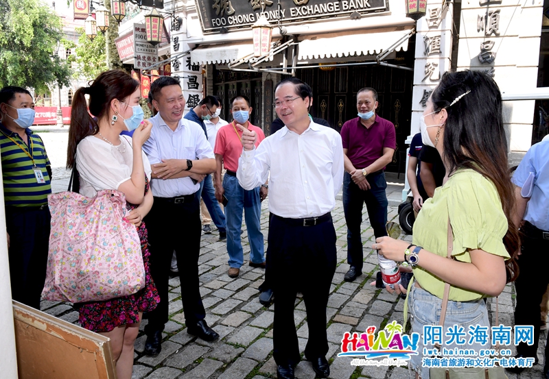 林光强在海口观澜湖冯小刚电影公社内与两名游客进行交流